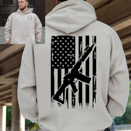 Back of sand-colored hoodie with American flag and rifle design, front featuring 1776 circle logo.