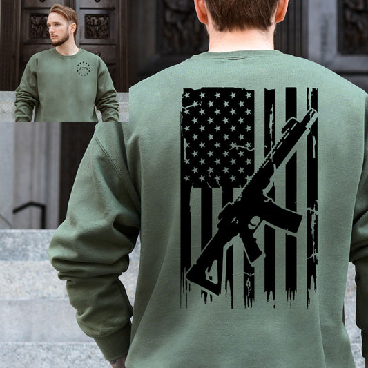 Military green crewneck for men featuring a patriotic 1776 logo on the front and American flag with AR-style rifle graphic on the back.