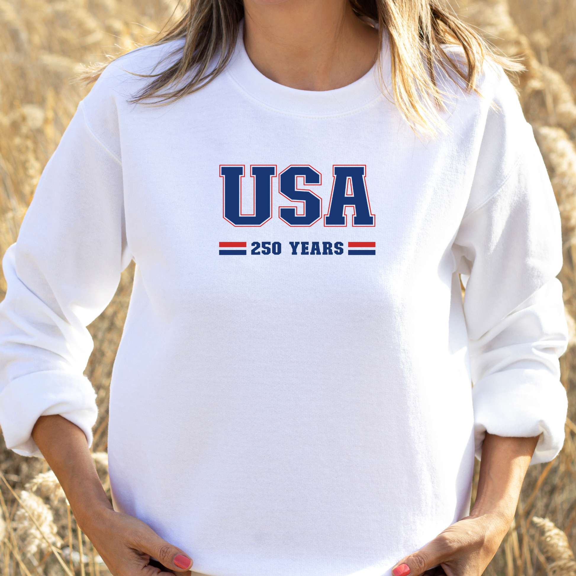 Person wearing a white sweatshirt with 'USA 250 YEARS' text in a field.