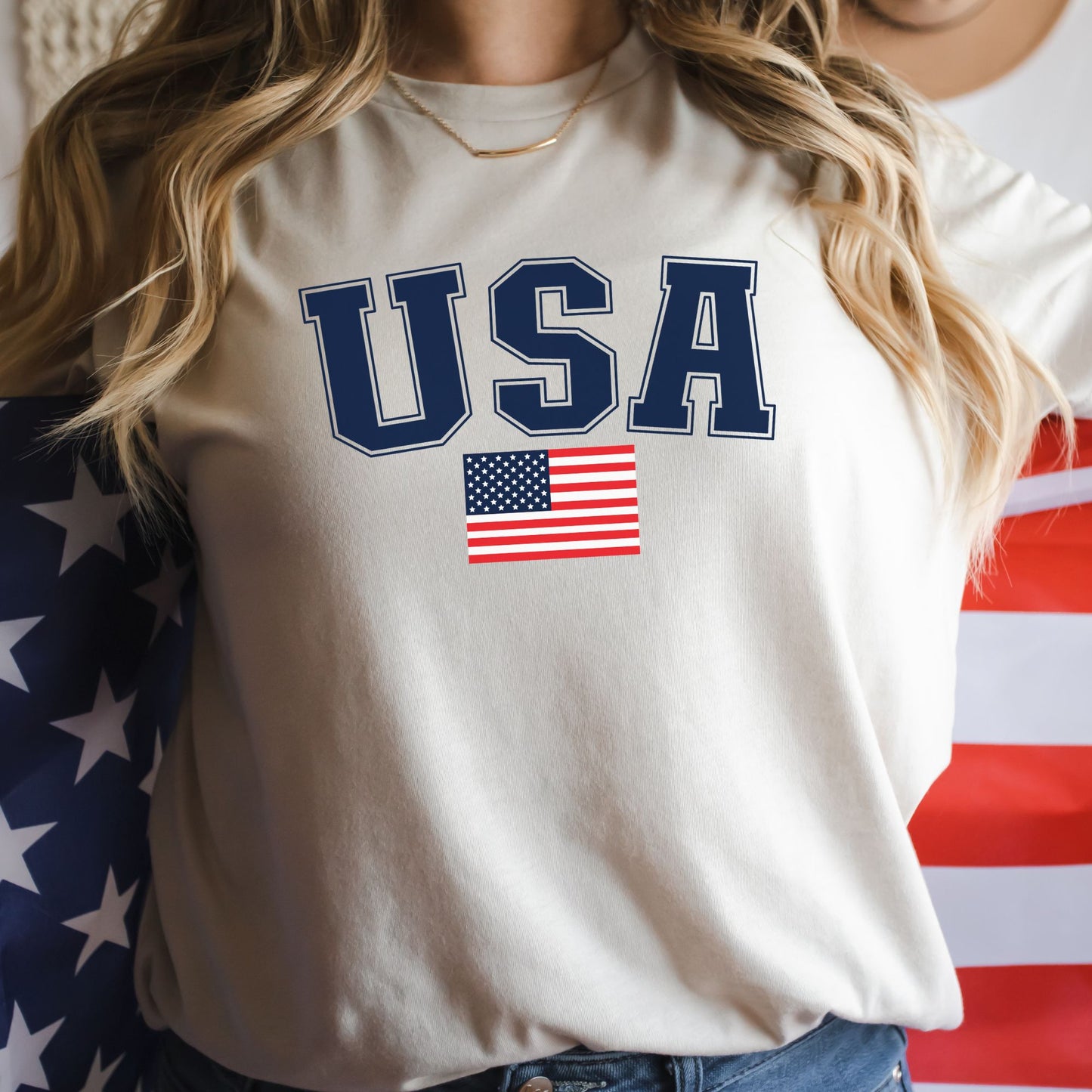 Close-up of a woman in a natural color USA flag t-shirt, wrapped in an American flag for a bold patriotic look.