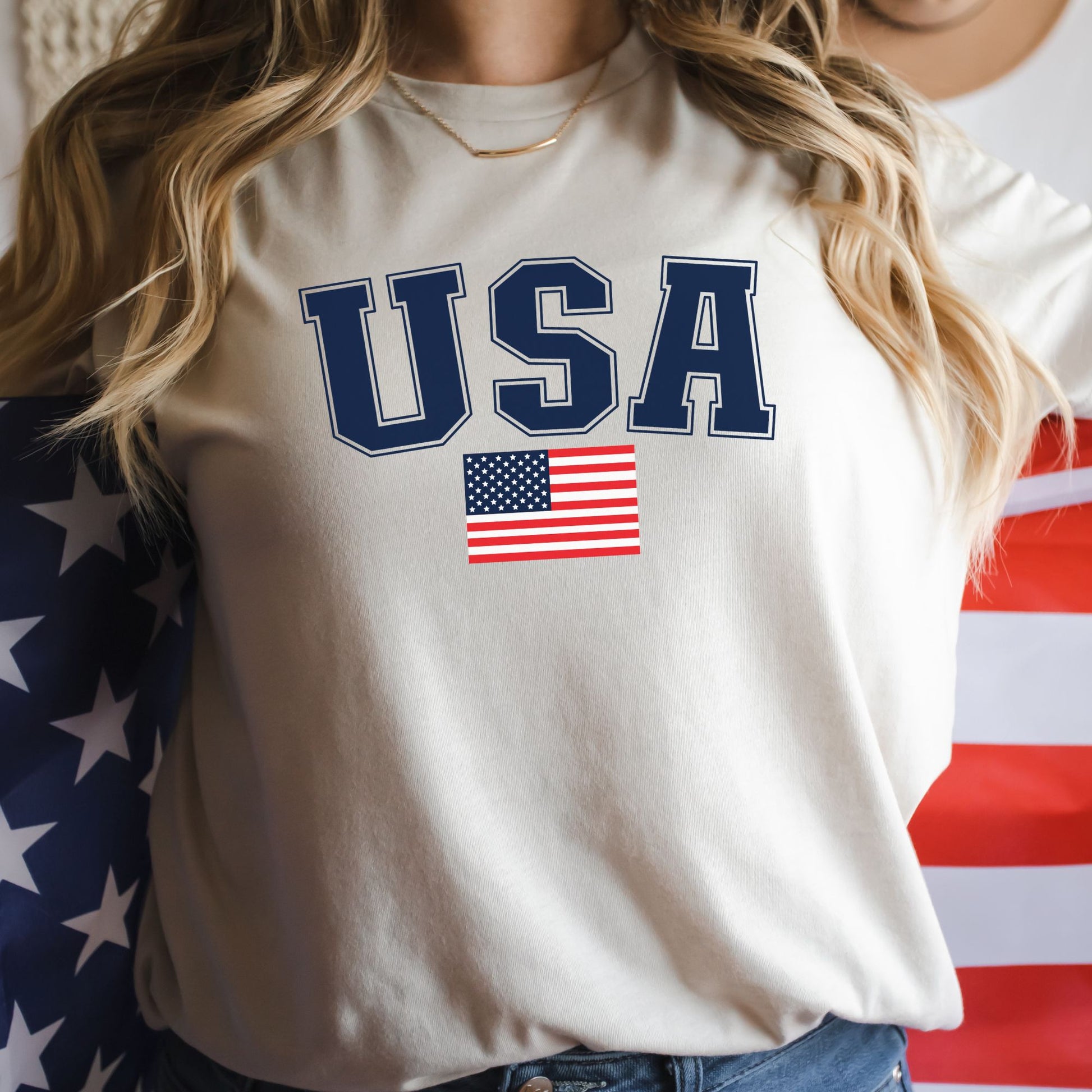 Close-up of a woman in a natural color USA flag t-shirt, wrapped in an American flag for a bold patriotic look.