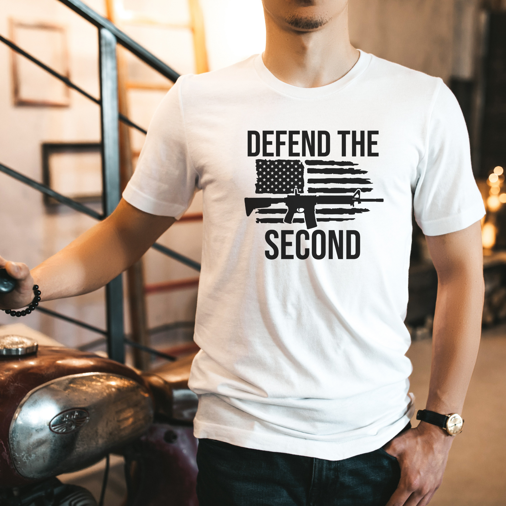 Patriotic men's t-shirt in white with "Defend the Second" design printed in black, featuring rifle and flag graphic.