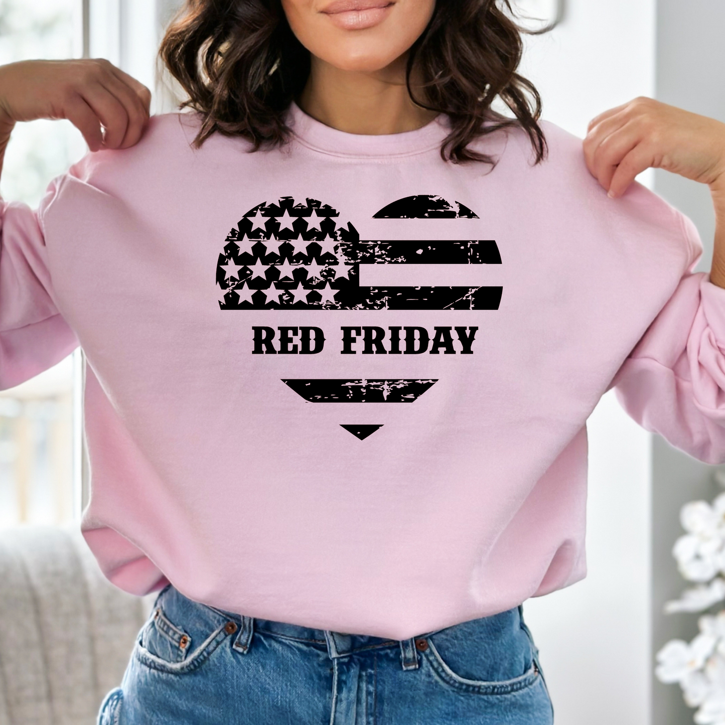 Red Friday distressed flag heart on soft pink crewneck sweatshirt, modeled indoors with casual style.
