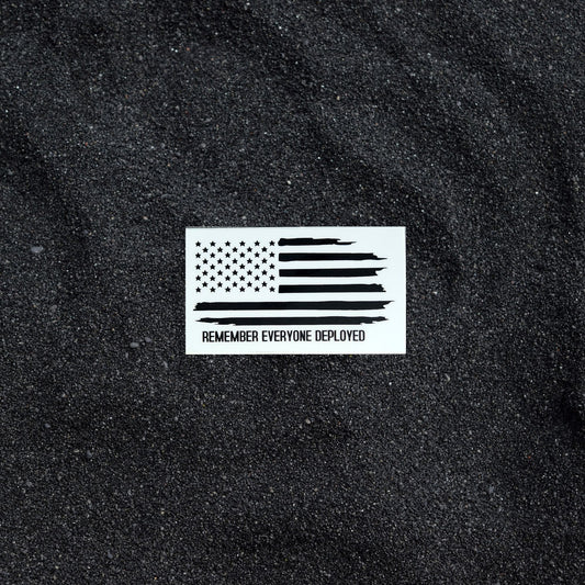 Remember Everyone Deployed sticker on black sand background.